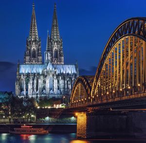 Illuminated bridge and cathedral in city at night