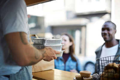 Midsection of man drinking coffee in cafe