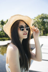 Beautiful woman wearing sunglasses looking away