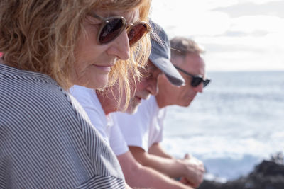 Side view of young woman using mobile phone at beach