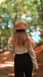 Rear view of woman standing against trees