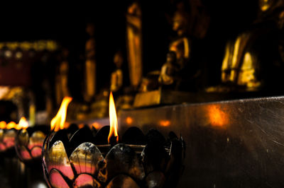 Close-up of illuminated candles in temple