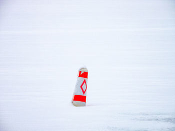 Red flag sign on snow covered land