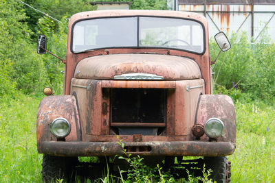 Old abandoned car on field
