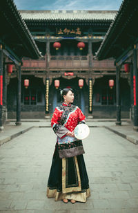 Young woman standing at courtyard of temple