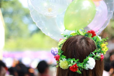 Rear view of woman wearing flowers standing outdoors