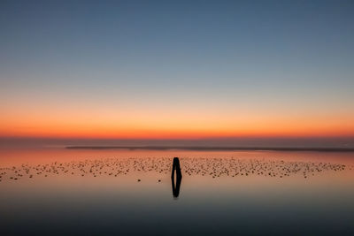 Scenic view of lagoon against sky during sunrise