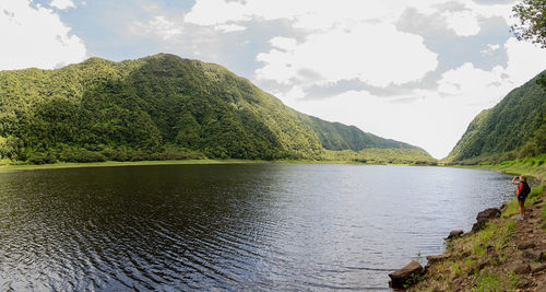 Scenic view of lake by mountains against sky