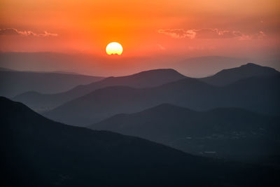 Scenic view of silhouette mountains against sky during sunset