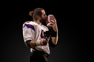 Full length of man standing against black background