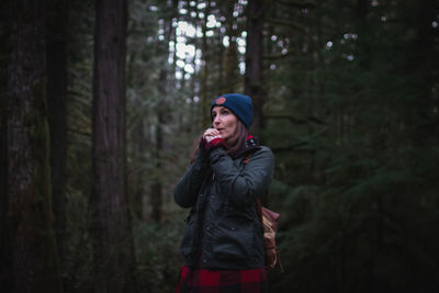 Young woman standing in forest