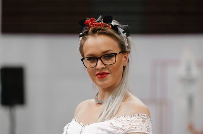 Portrait of young woman standing against white background