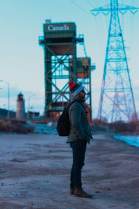 Rear view of man standing on bridge against sky