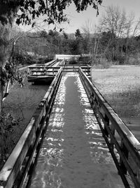 Footbridge over canal against sky