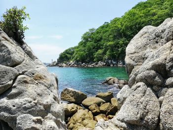 Rocks by sea against sky