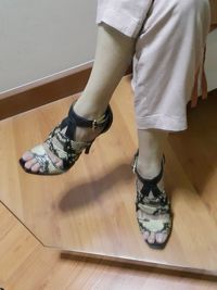 Low section of woman standing on hardwood floor