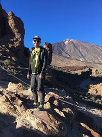 Full length of male hiker standing on rock