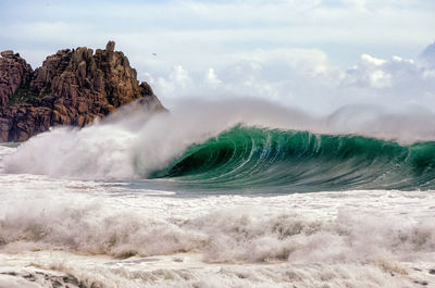 Waves flowing in sea against sky