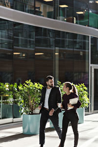 Business professionals talking while walking in office lobby