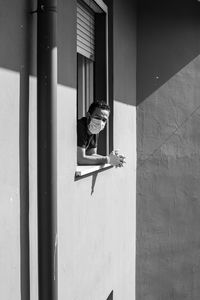 Full length of girl sitting on wall