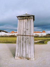 View of old wooden post on field against sky