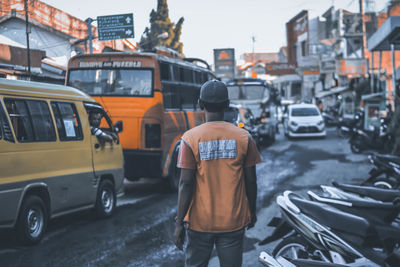 Rear view of man working on city street