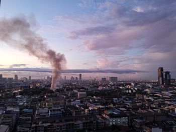 Smoke emitting from chimney against sky in city