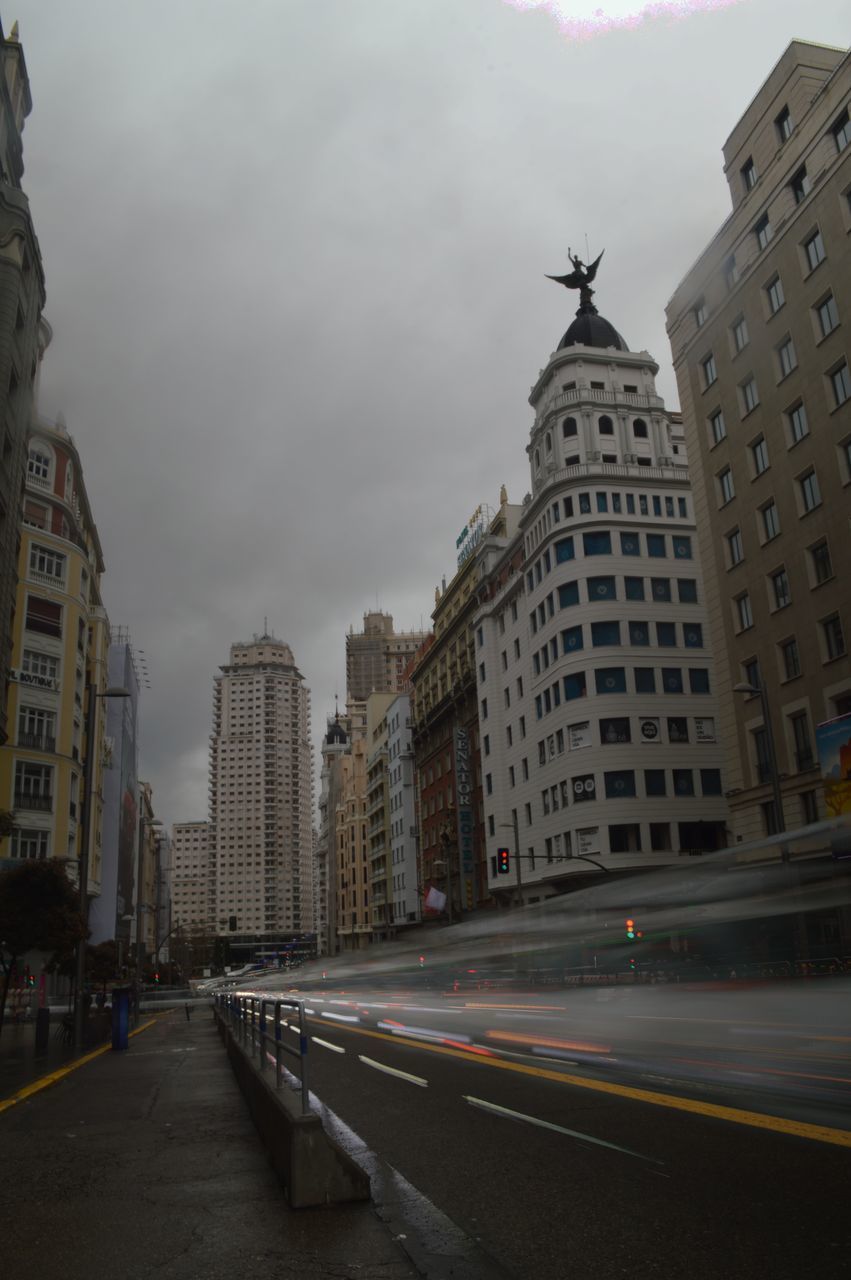 CITY STREET AMIDST BUILDINGS AGAINST SKY