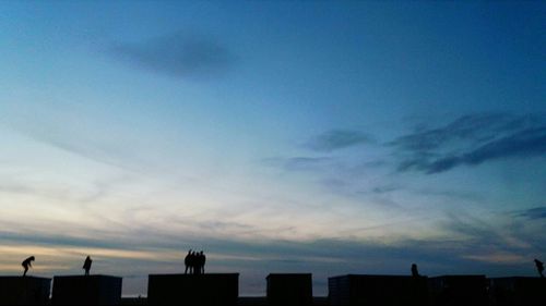 Low angle view of silhouette buildings against sky