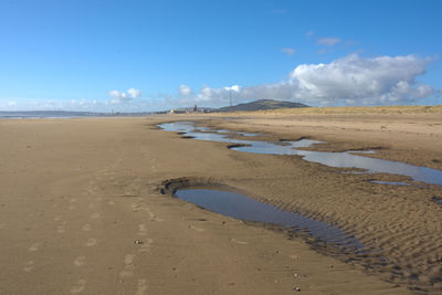 Scenic view of beach against blue sky