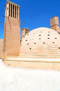 Low angle view of historical building against clear blue sky