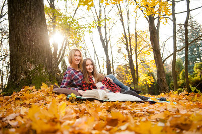 Young woman sitting in park during autumn