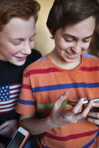 Happy boys using mobile phone in high school