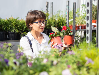 Woman holding potted plants at shop