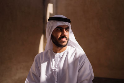 Portrait of young man standing against wall