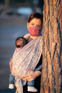 Mother with newborn in the new born sash in outdoor photo