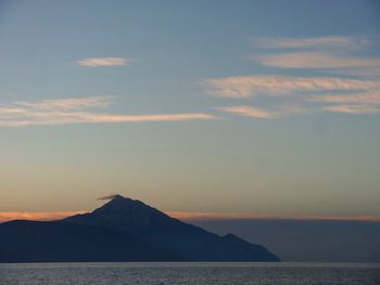 Scenic view of sea and mountains against sky