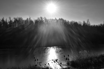 Scenic view of lake against bright sun