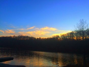 Silhouette of trees and lake at sunset