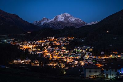 Illuminated cityscape against sky at night