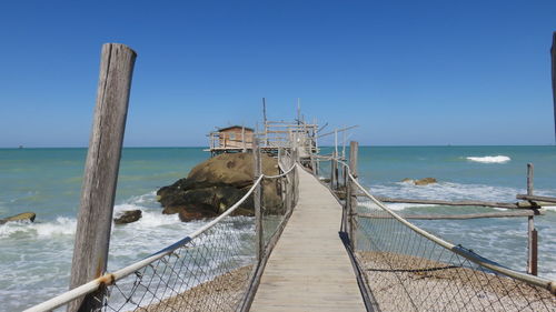 Long narrow jetty at calm blue sea