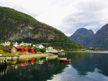 Scenic view of lake by buildings against sky