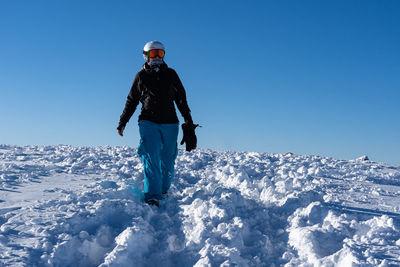 Full length of man standing on mountain against clear blue sky