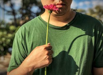 Midsection of man holding flower