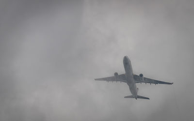 Low angle view of airplane flying against sky