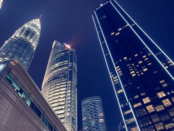 Low angle view of illuminated buildings against clear sky at night