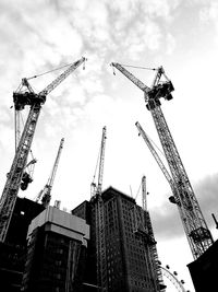 Low angle view of cranes at construction site
