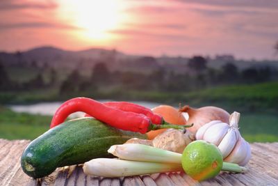 Close-up of fresh fruits on table against sky during sunset