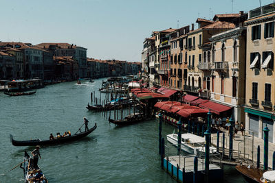 Boats moored in canal against buildings in city venice italy