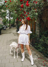 Portrait of young woman with dog on street